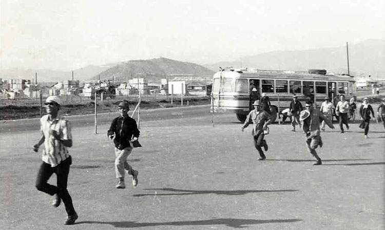 11. Nui Dat: Civilian Vietnamese workers running to work frombus. Photo by Dana Anthony, ND 1969.