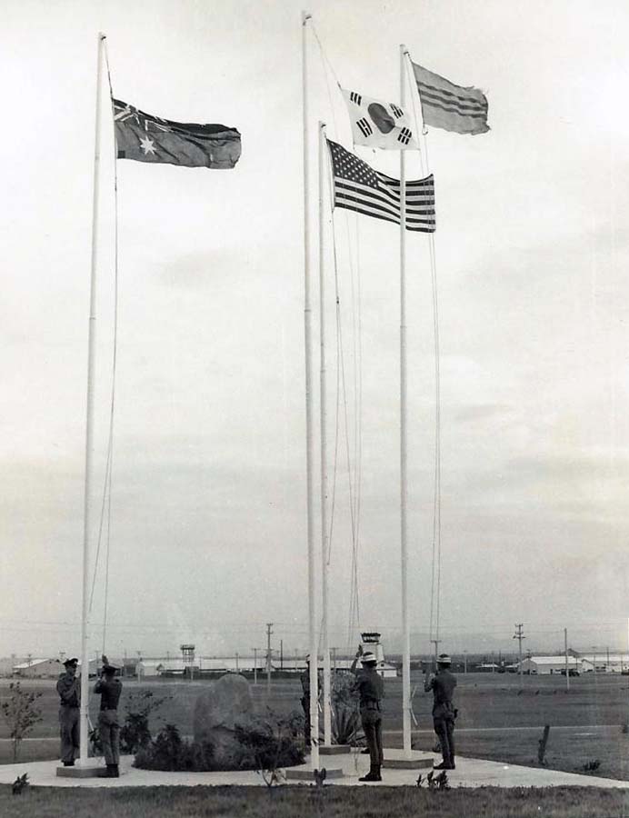 12. Nui Dat: Australian Base. Allied troops raise national flags. Photo by Dana Anthony, ND 1969.